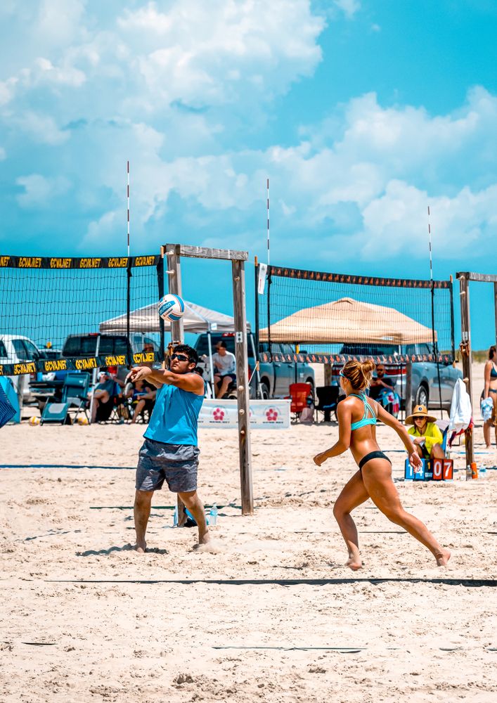 A man and a woman playing beach volleyball at Apffel Beach Park.
