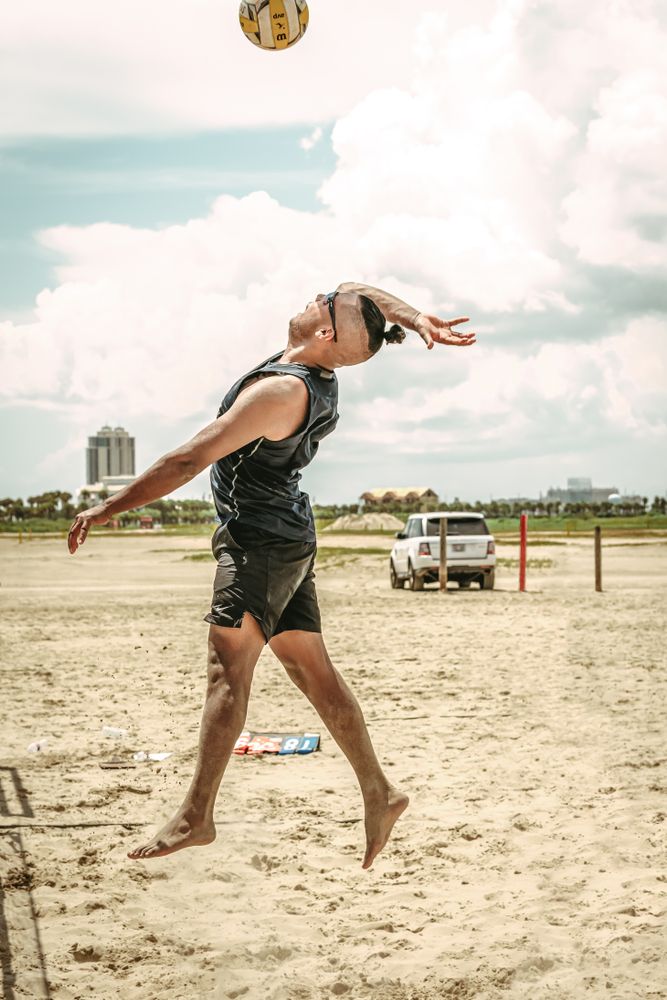 A man striking the volleyball at Apffel Beach Park.