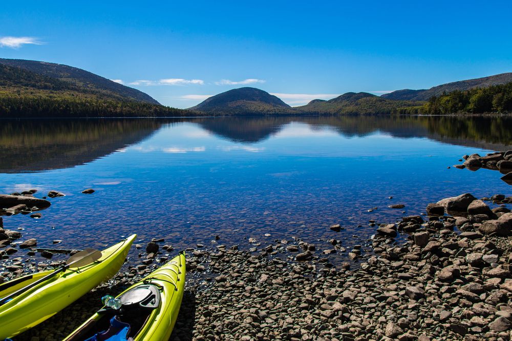 Kayaks resting on a rocky shore