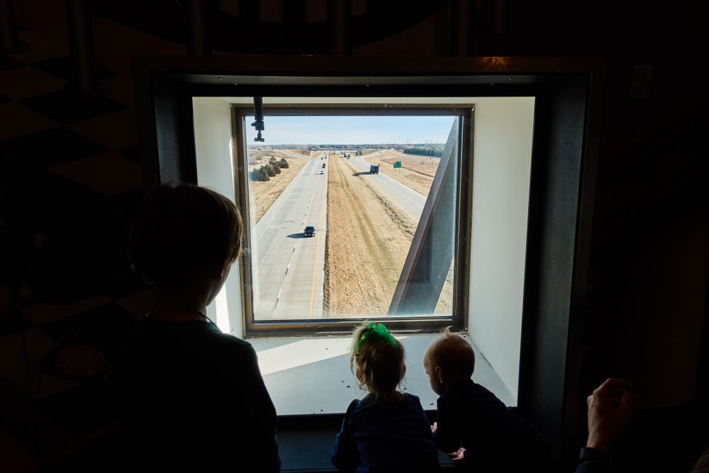 People looking over the highway through the window at Archway Monument