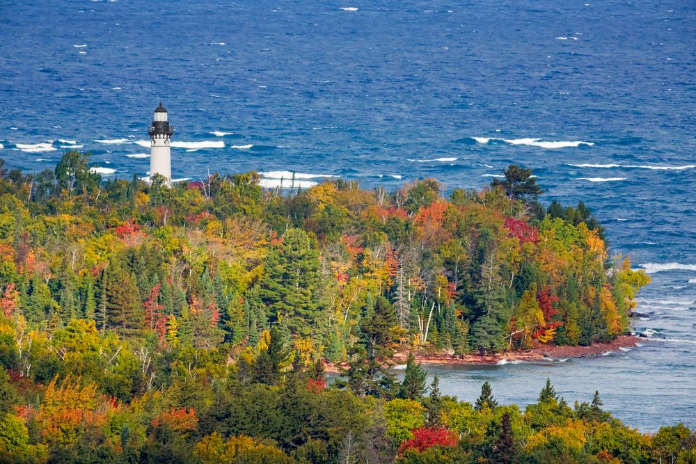 Au Sable Light Station surrounded by tall trees with autumn leaves