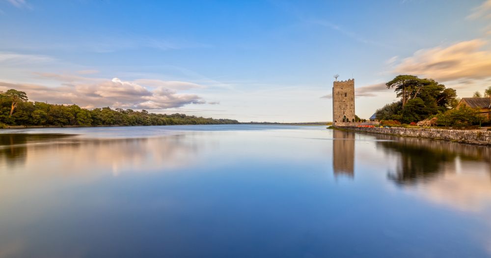 Distant view of Belvelly Castle with its reflection on the water