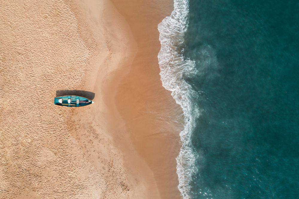 Aerial view of turquioise water crashing on the shores of Cape May Beach