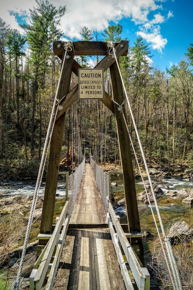 Narrow wooden swinging bridge over Cheoah River