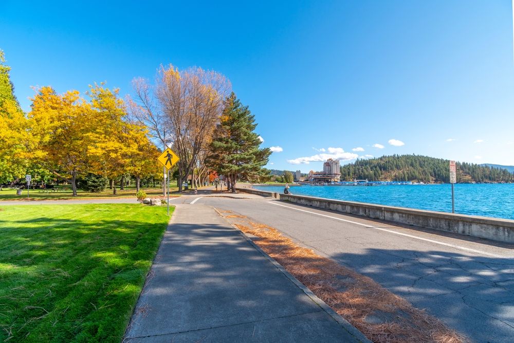 Scenic view of road, lawn and beach at Coeur d'Alene City Park