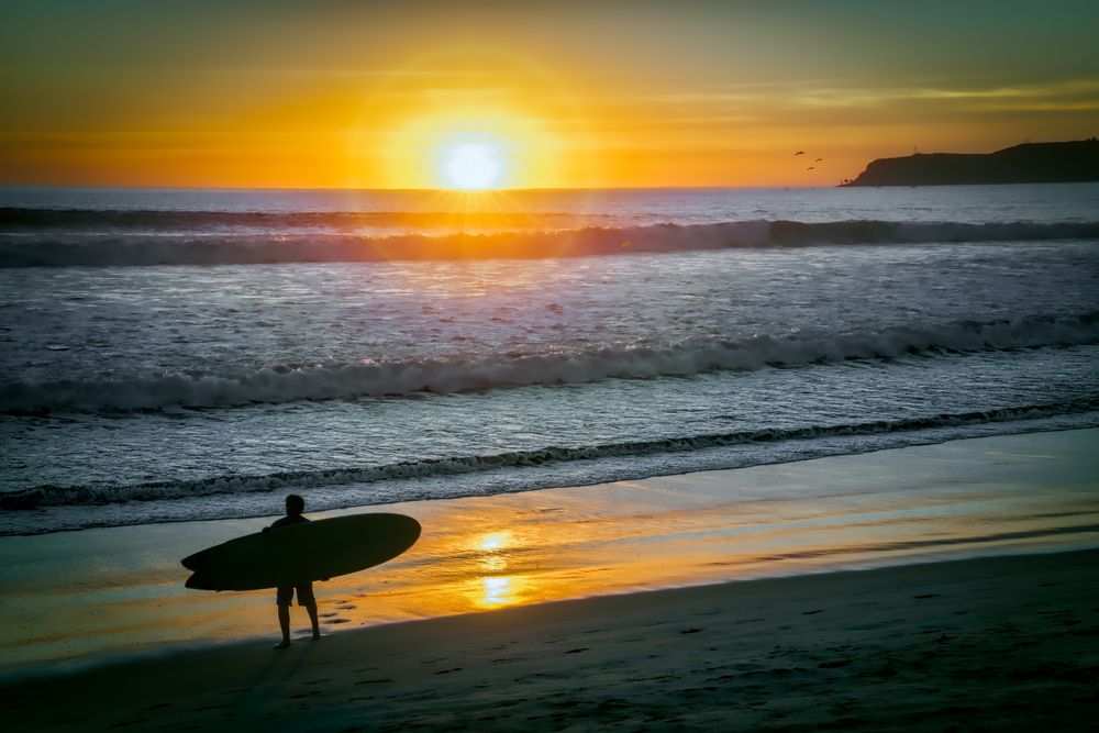 Silhouette of a surfer at Coronado Beach during sunset