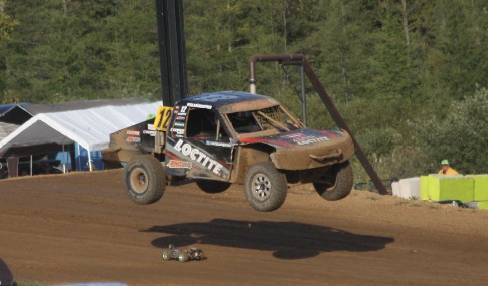Dirty black truck racing in Crandon International Off-Road Raceway