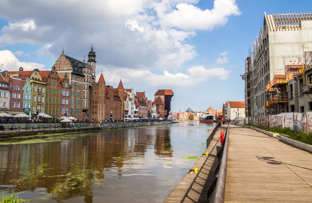 Scenic view of Długie Pobrzeże with river, buildings, and walkway