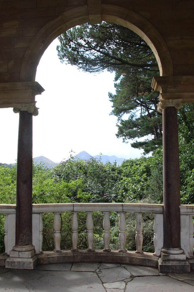 View of the greenery at Garnish Island through the arches of an old building