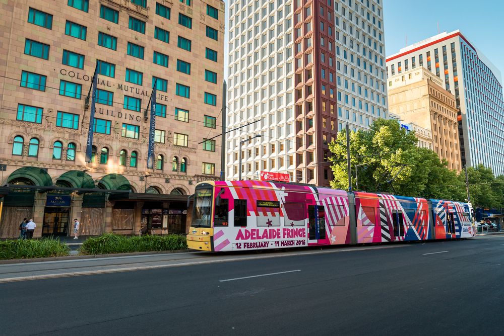 Glenelg tram passing through some tall buildings in Adelaide