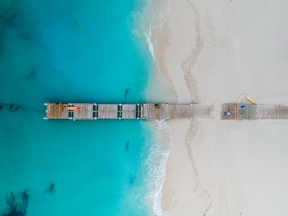 Aerial shot of Grace Bay with its beautiful blue water and wooden pier