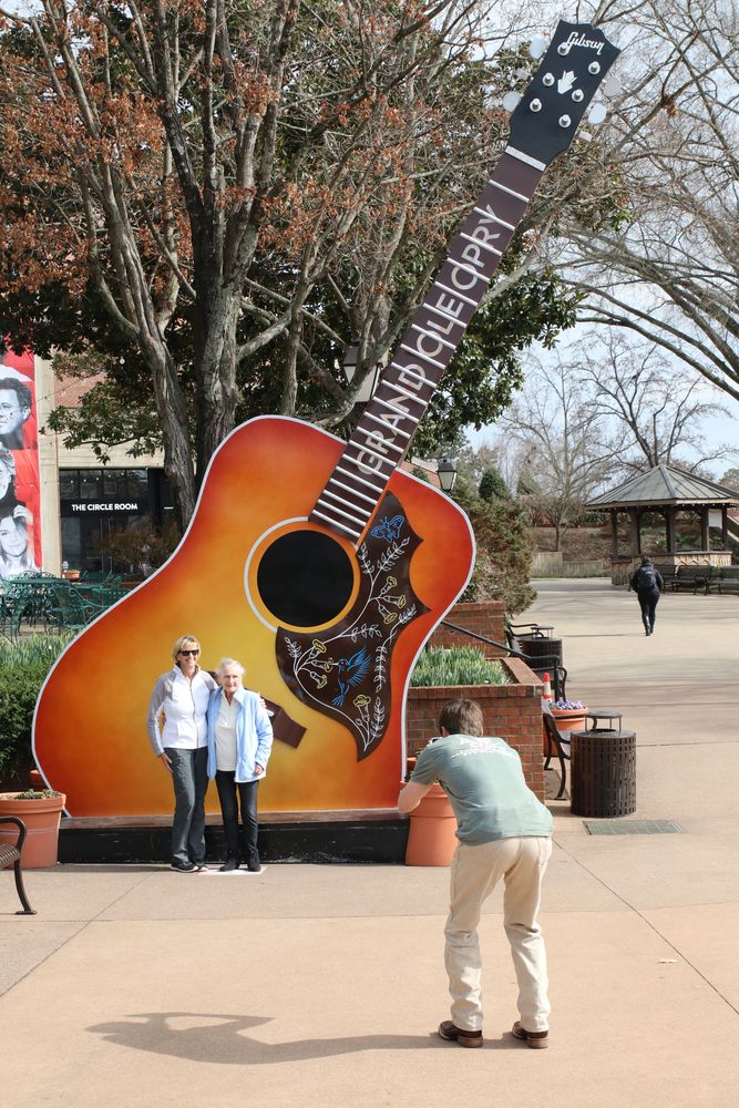 People clicking pictures in front of the giant guitar placed outside the Grand Ole Opry