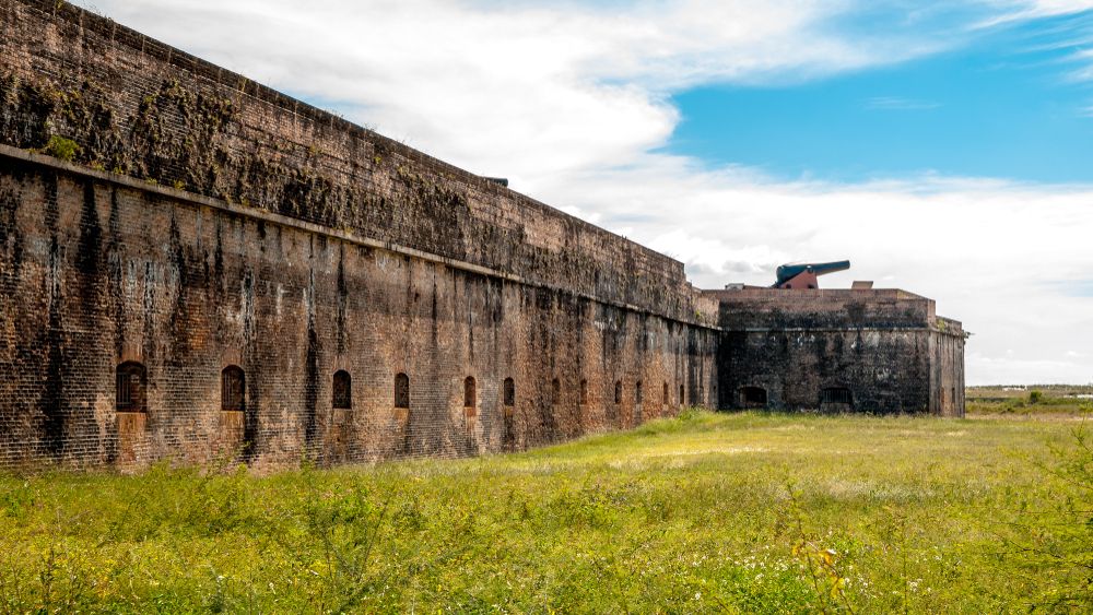 The old walls of fort pickens with a bed of green grass.