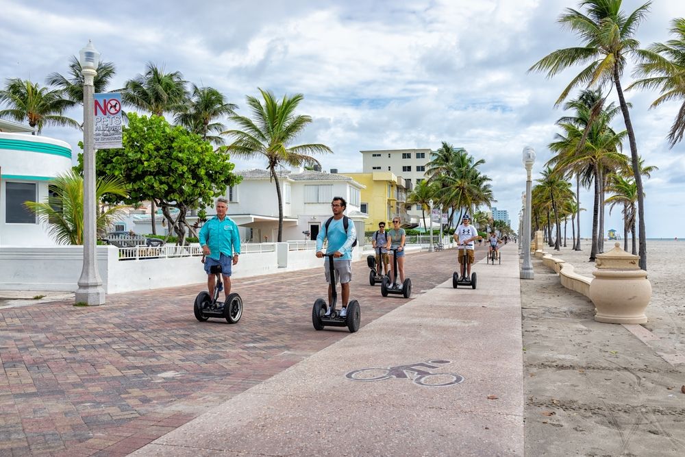 Visitors riding scooter to explore the Hollywood Beach Broadwalk
