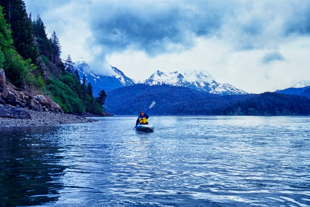 A lonely man rowing his boat at Kachemak Bay State Park