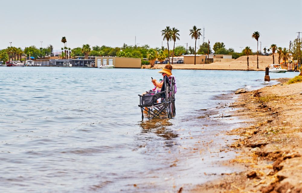 Two people sitting on chairs at Rotary Park's shore
