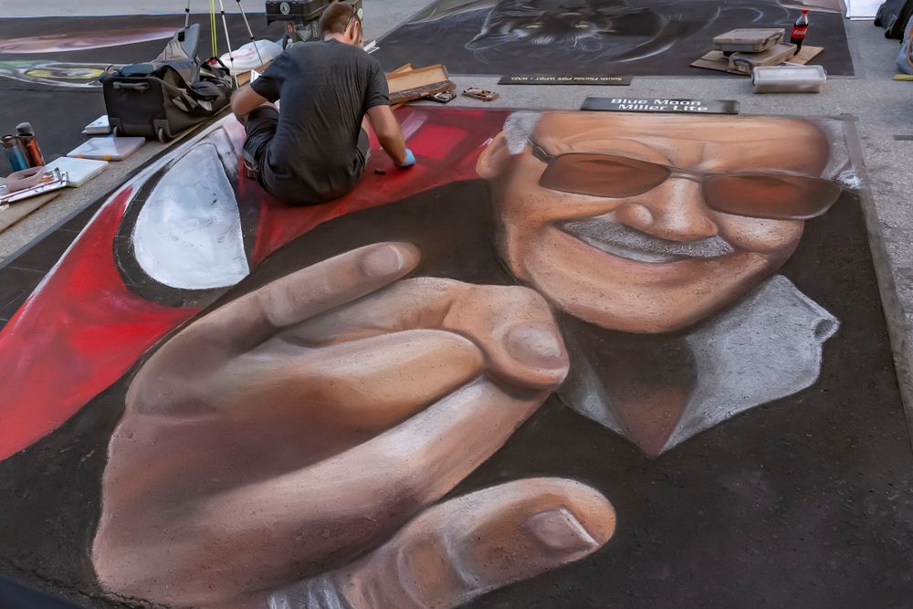 An artist adding details to his painting at Lake Worth Street Painting Festival