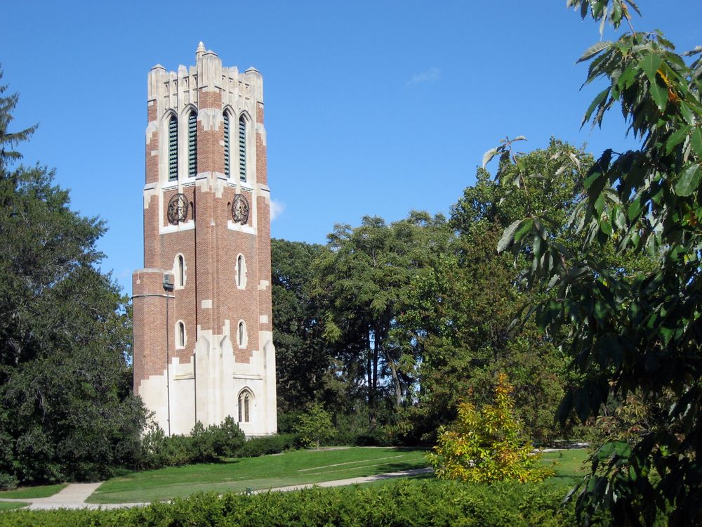 Lansing Beaumont Tower standing tall amids the huge trees and plants