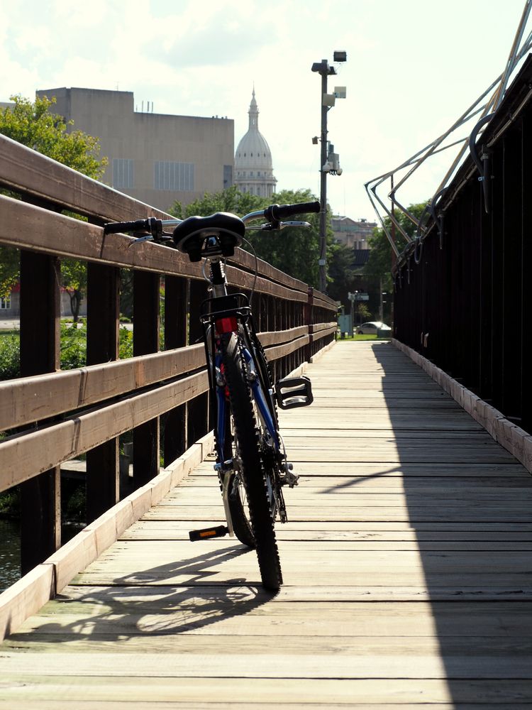 A bike parked along the wooden pathway of Lansing River Trail
