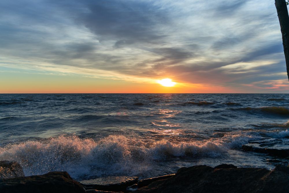 Stunning view of waves crashing on the rocks in the shore of Marblehead during sunset