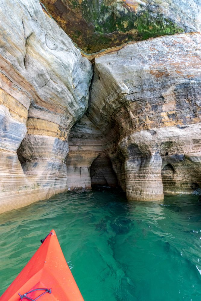 Red kayak in front of the intricate rock formation at Miners Castle