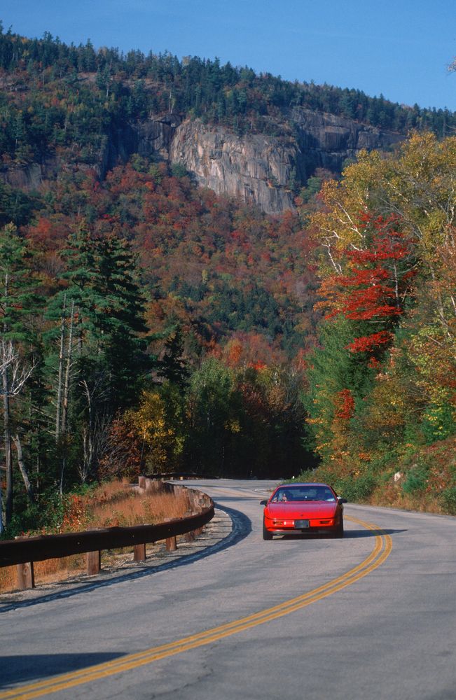 A car passing by the scenic New Hampshire Route 112