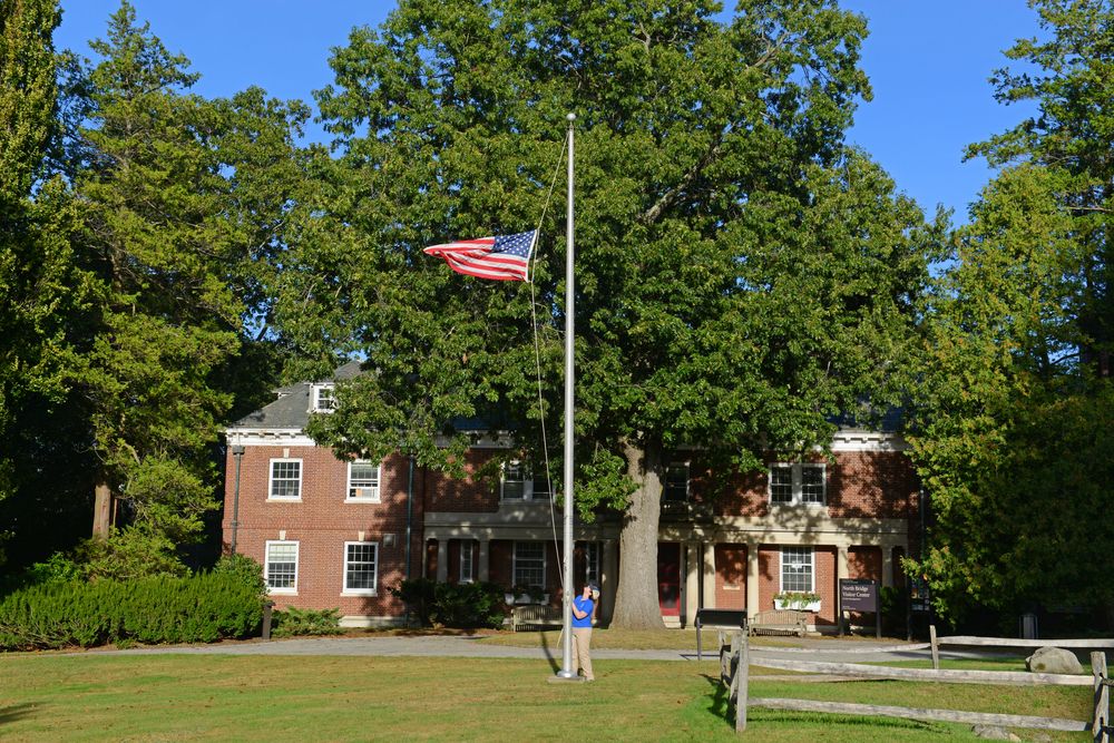 A young man hoisting American flag at North Bridge Center