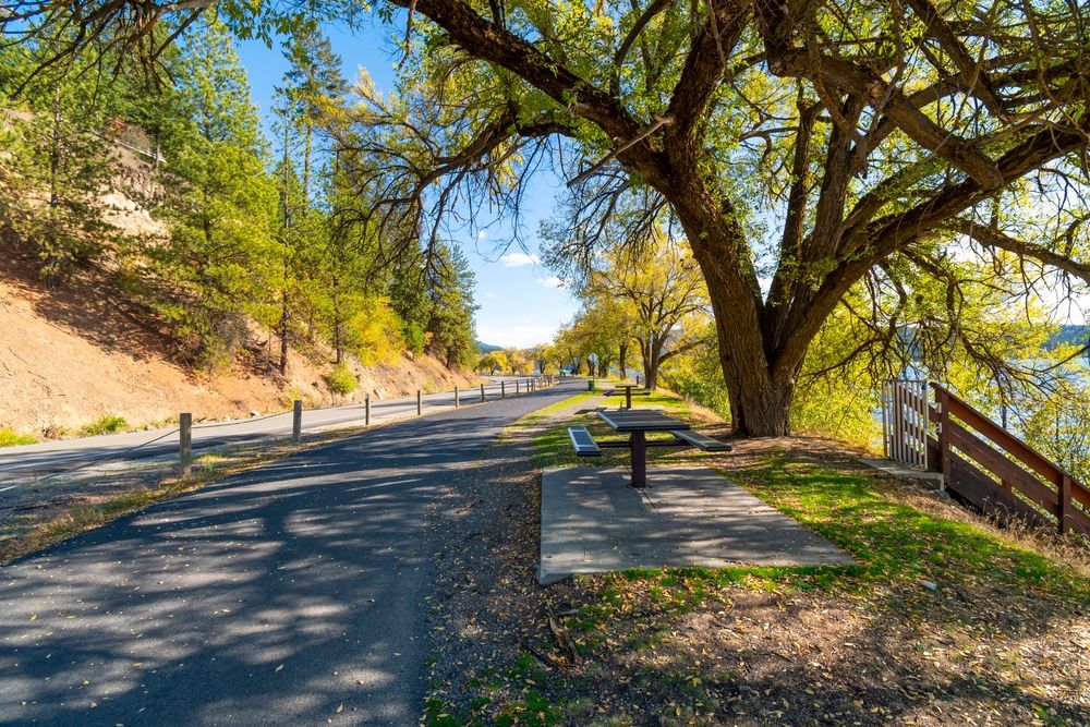 Picnic bench placed on the pavement along the North Idaho Centennial Trail