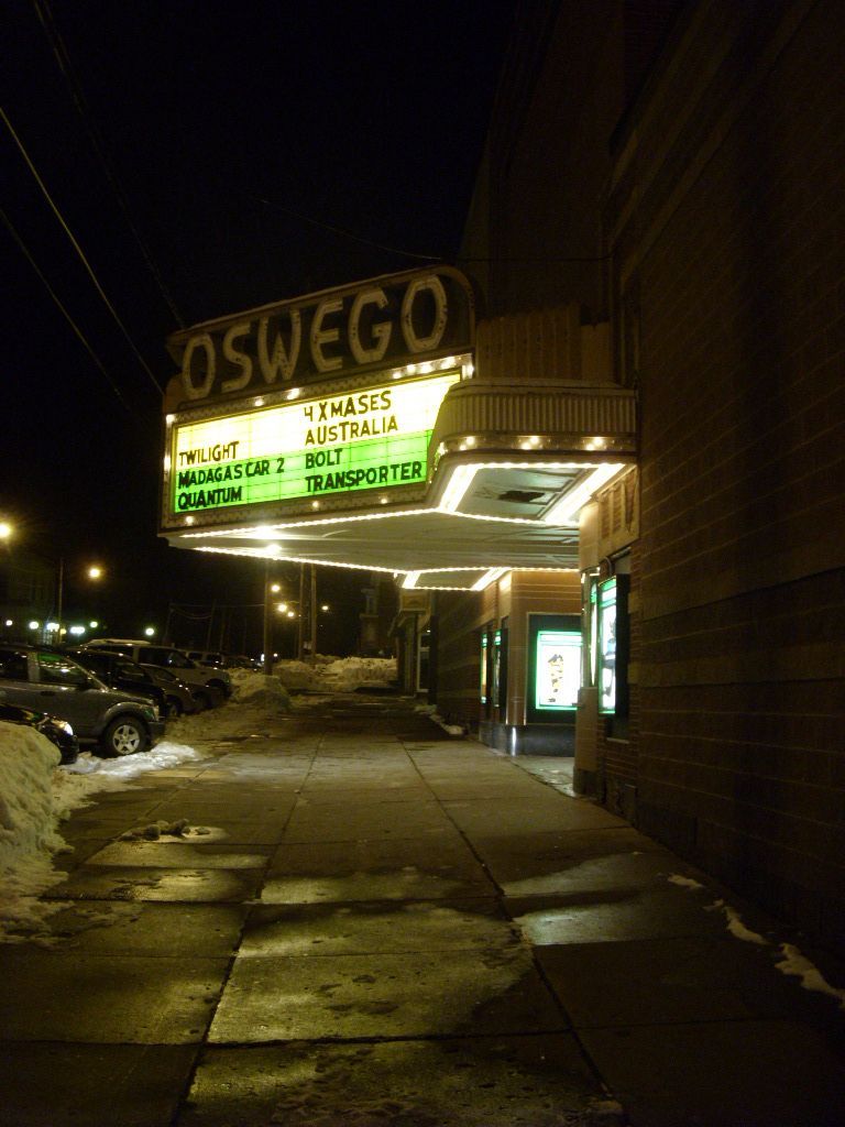 Oswego Theater/Cinema 7 at night with movie titles in front.