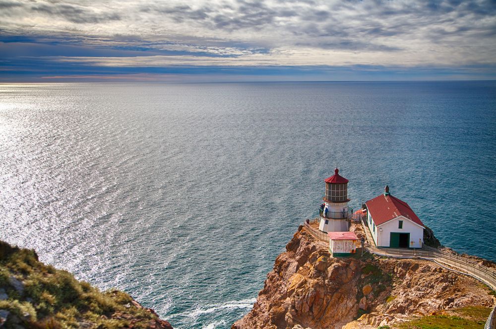 Aerial view of the Point Reyes Lighthouse and the vast waters behind.
