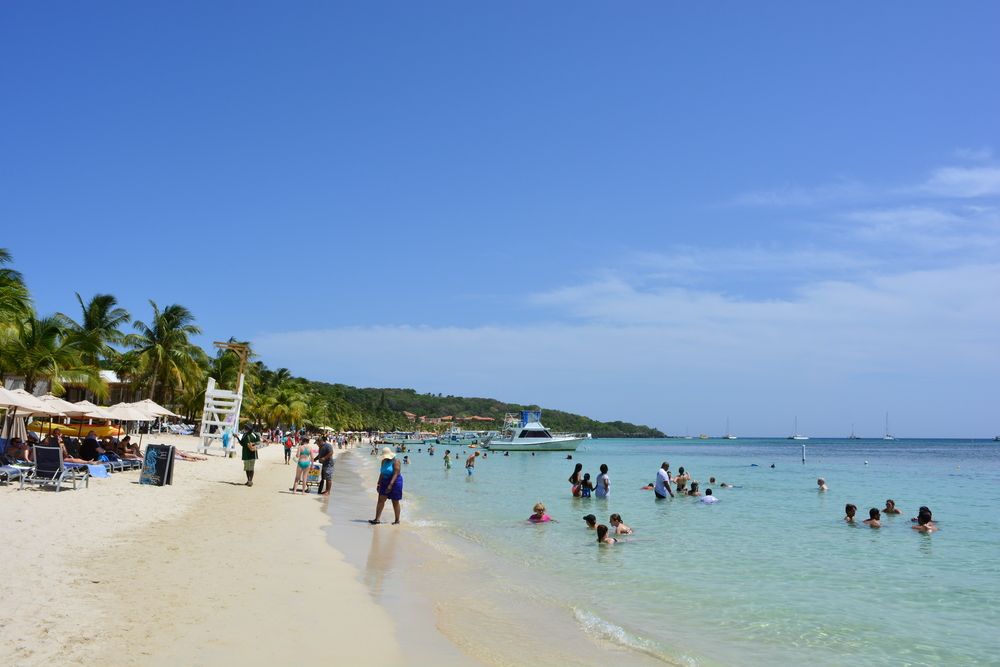 Tourists enjoying the sun and the waters of West Bay Beach