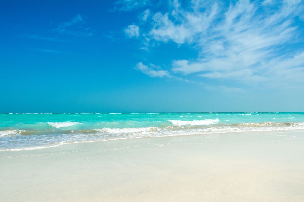 Turquoise blue waves crashing on the white sands at Saadiyat Beach