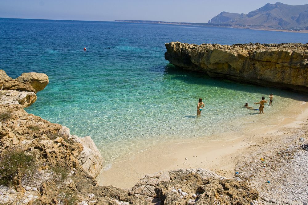 A family swimming on the beach at San Vito Lo Capo