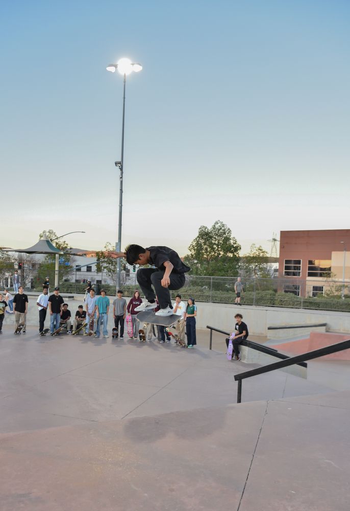 A young boy performing a skate stunt at Santa Clarita Skate Park