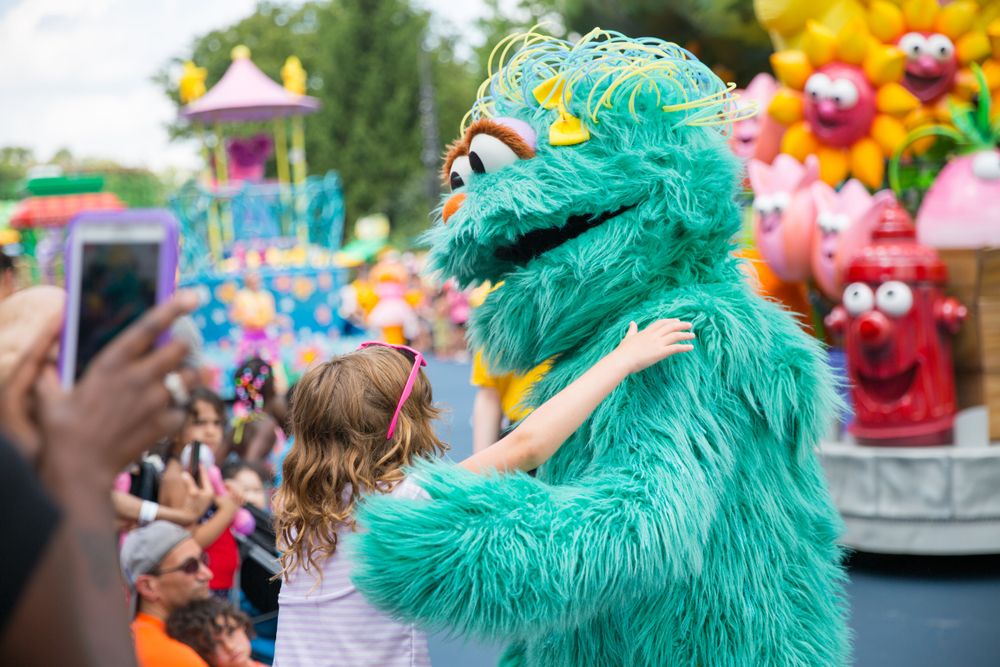 A person dressed like Sesame interacting with the kids at Sesame Place