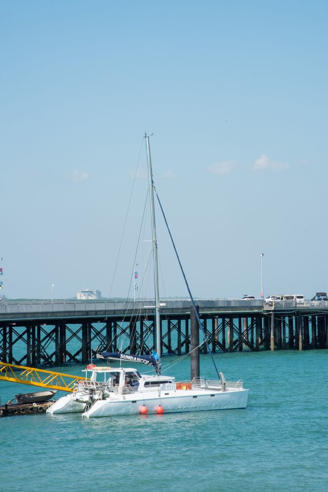 Sailboat with fishing pier in the background at Stokes Hill Wharf