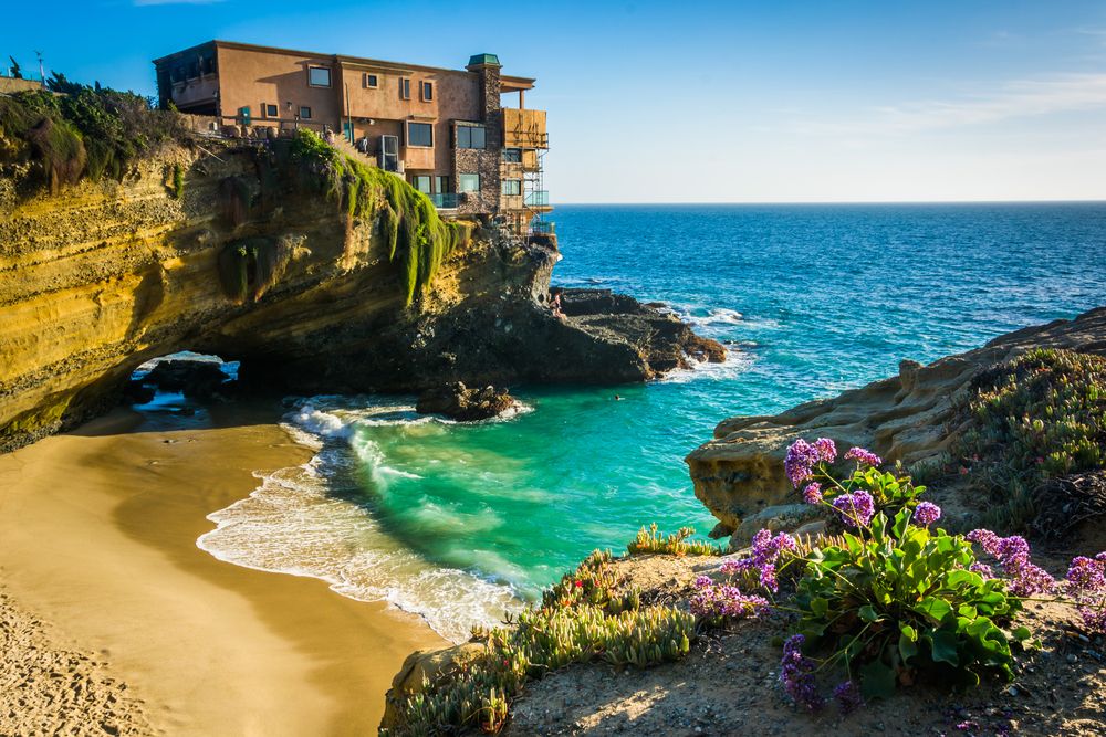 Picturesque view of the turquoise blue water and a house on the cliff at Table Rock Beach