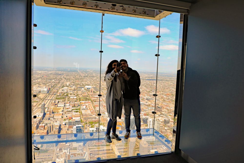 A couple posing at Willis Tower Skydeck