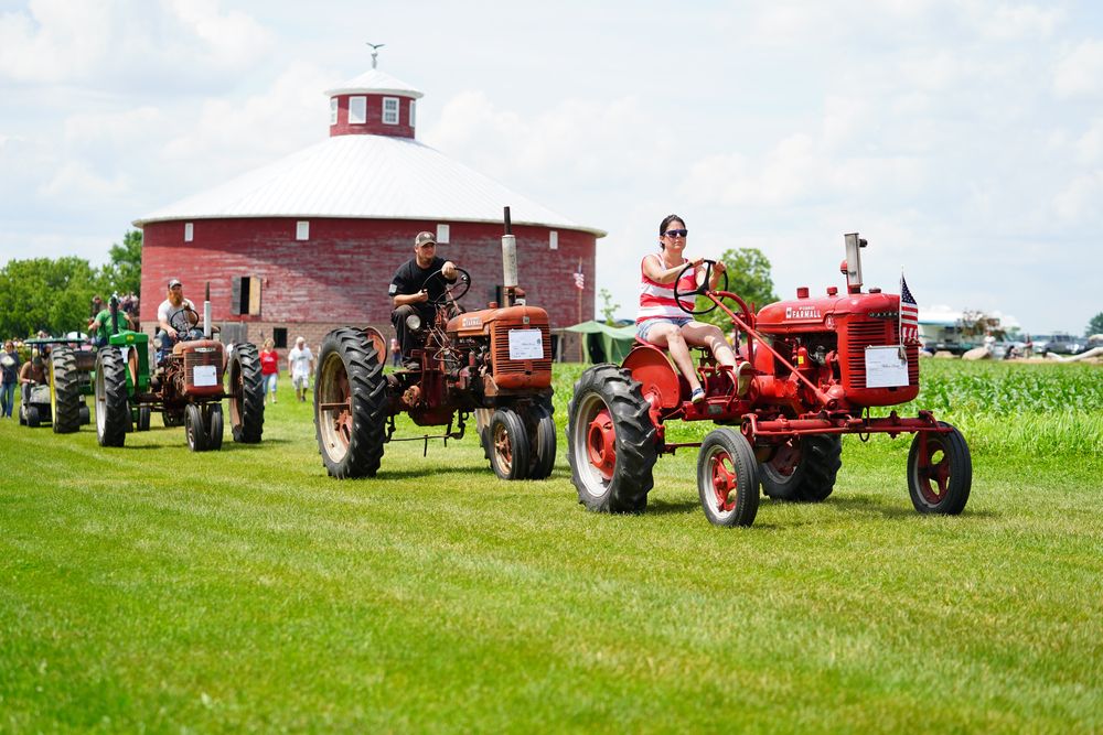 People driving vintage tractors at Willow Springs Garden