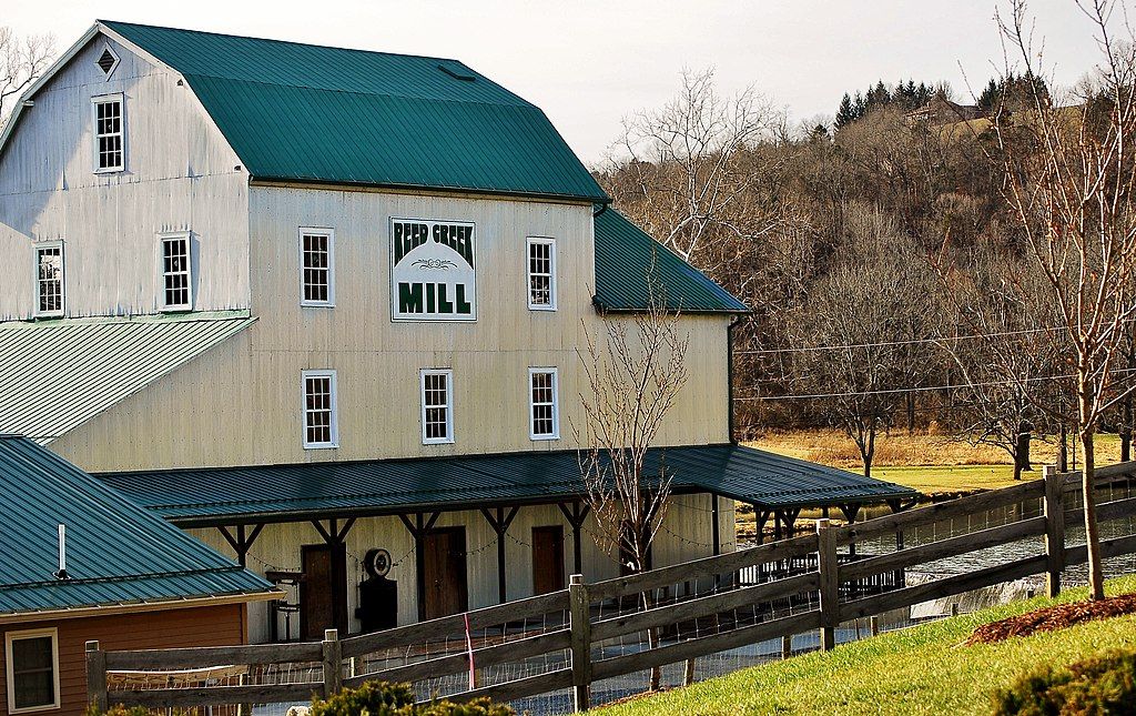 Exterior of the Reed creek mill with blue-green roof and white windows.