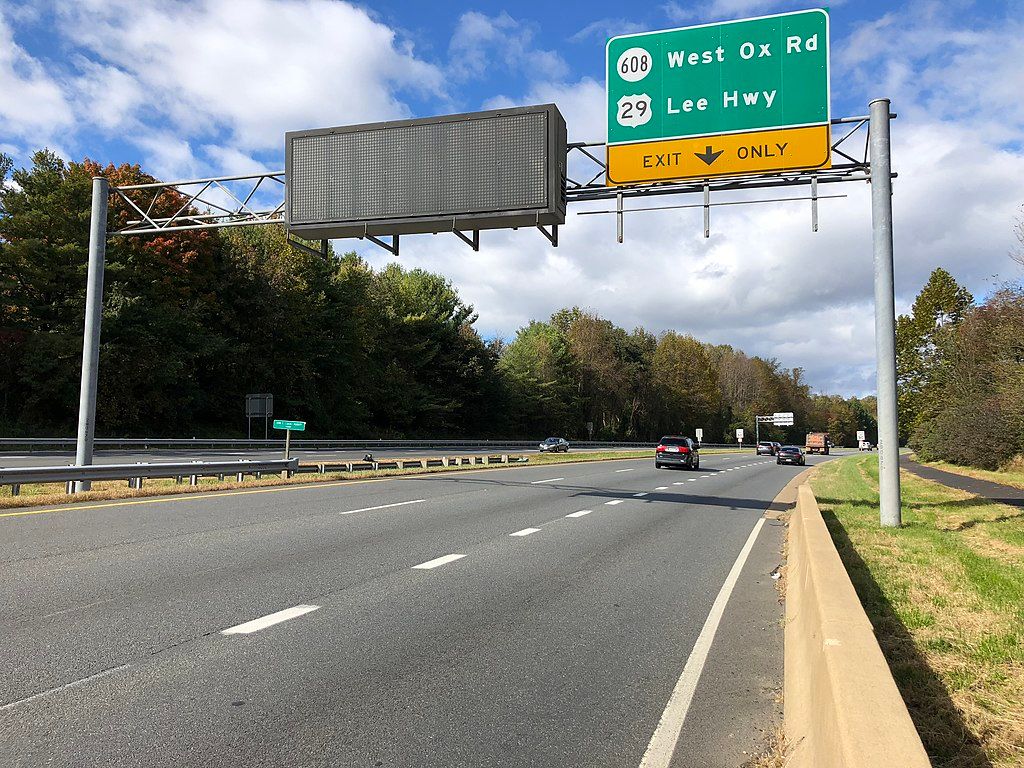 Lee highway sign with cars driving along the road.