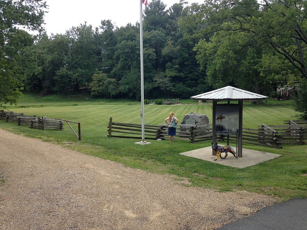 The muster grounds trail with tall trees and clean cut grass.