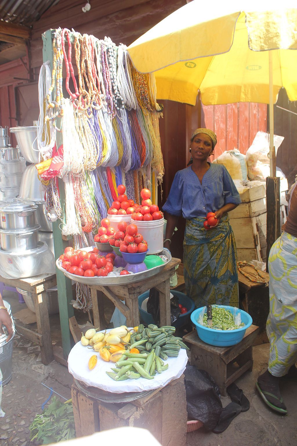 A vendor selling jewelry and fruits at Makola Market