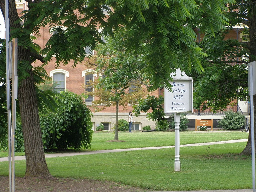 Welcoming sign post of berea college on clean cut grass.