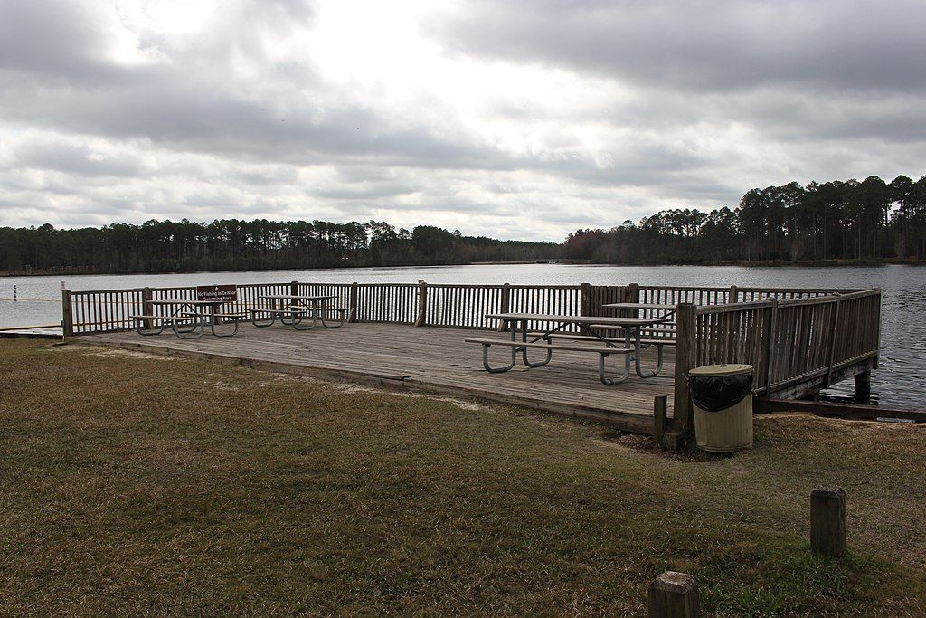 Picnic tables on a deck over Laura S. Walker State Park's lake