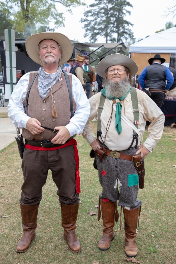 Two men dressed up as cowboys.