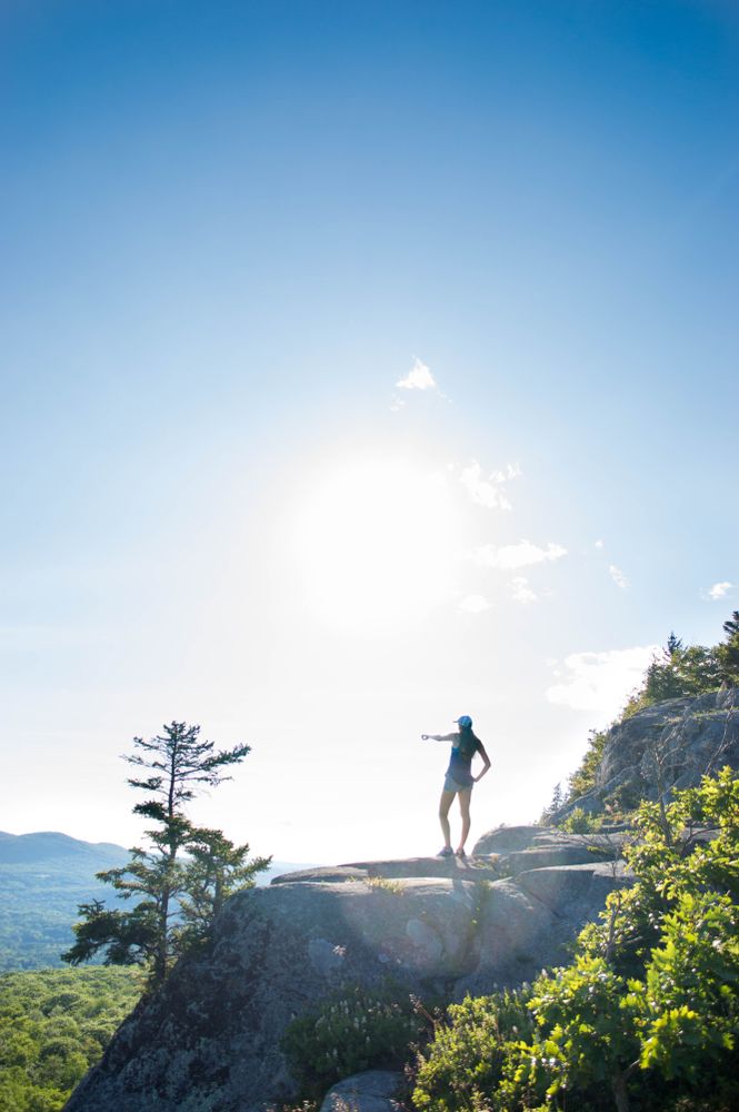 A hiker's silhouette at the peak of Camden Hills State Park