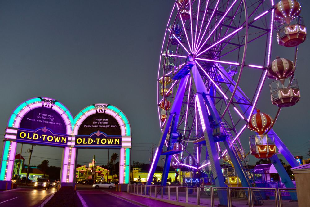 Night view of the Old Town Theme Park's entrance and ferris wheel