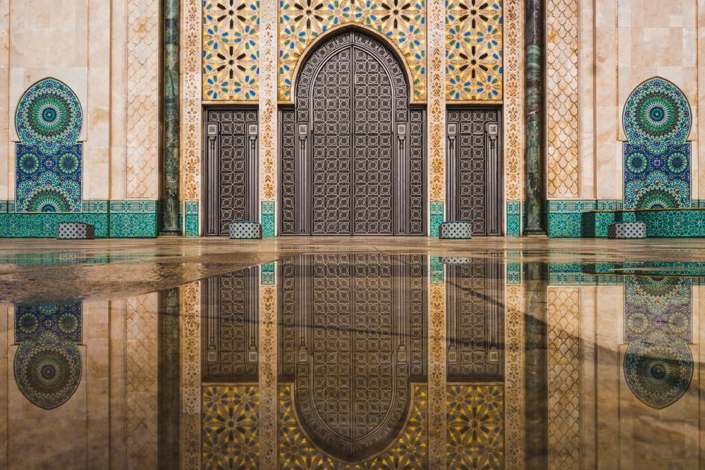 Hassan II Mosque's gate reflecting on rain water