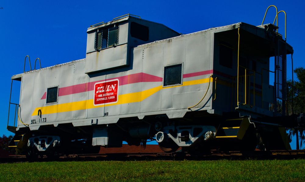 A train caboose displayed on the grounds of Zephyrhills Train Depot Museum